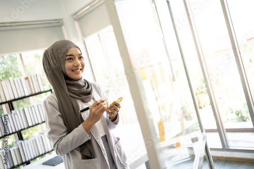 Fotografía Muslim Business Woman in Hijab with Documents at Workplace in Office