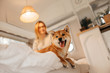 happy shiba inu dog and owner posing on a bed indoors