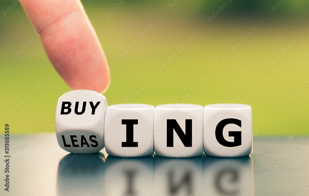 Hand turns a dice and changes the word "leasing" to "buying", or vice versa. - obrazy, fototapety, plakaty 