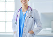 © lenets_tan - Young doctor woman standing near table, isolated on white background