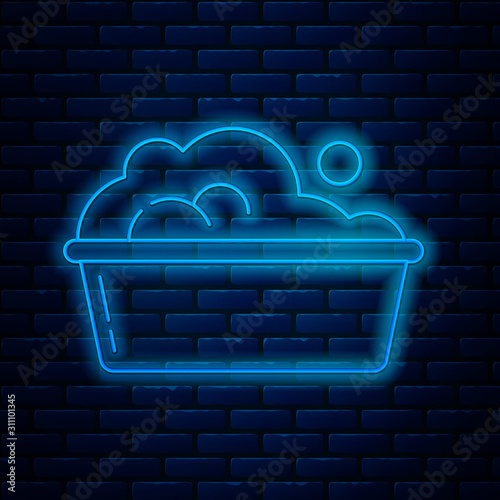 Fotomural Glowing neon line Plastic basin with soap suds icon isolated on brick wall background
