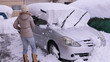 © kelly marken - スノーワイパーで自動車の屋根の雪を降ろす女性