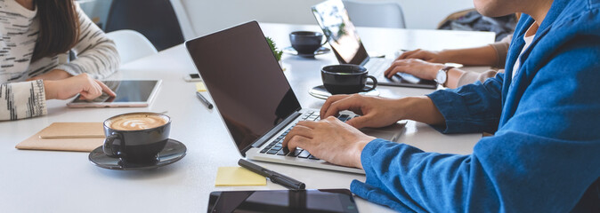 Businesspeople using and working on laptop computer and tablet pc on the table in office