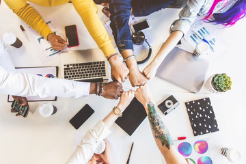 Wall Mural - Group of multi ethnic executives discussing during a meeting. Business man and woman sitting around table at office and smiling. A team of young creative designers