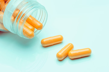 beautiful orange capsules with bottle, medicines for health, pharmaceutical health care and sciences concept, sweet color tone effect