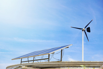 wind turbine and solar cell panels on blue sky