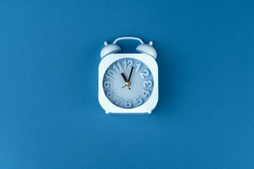 Wall Mural - Top view of alarm clock on classic blue background