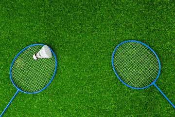 Wall Mural - Badminton game rackets and shuttlecock on grass