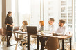 © xartproduction - A team of young businessmen working and communicating together in an office. Corporate businessteam and manager in a meeting. desktop against the background of the pan window, free space for text