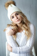 © ElenaBatkova - Close-up portrait of a woman in a white hat and white woolen sweater.