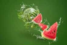 Water Splashing On Sliced Of Watermelon On Green Background