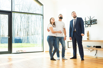 Wall Mural - real estate agent shows a young couple a new home. family buys housing