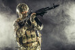 © alfa27 - special forces soldier man holding machine gun and military equipment in smoky space