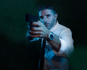 Wall Mural - Man pointing handgun - dramatic action portrait of attractive special agent or police officer aiming with gun in white shirt and tie holding the weapon serious in law enforcement