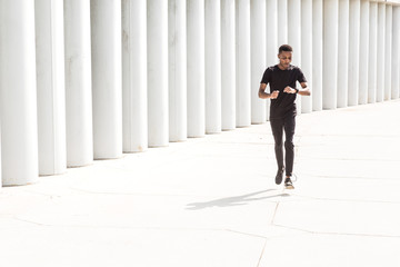 Sticker - Athletic young afroamerican man running on the promenade. Black Male runner sprinting outdoors. Healthy lifestyle concept.