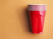 Red Plastic Cups On A Brown Background.