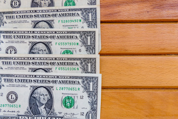 Heap of the one dollar banknotes on wooden background. Top view