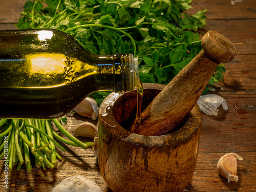 Cuadros en Lienzo Close-up of a mortar and pestle with garlic, fresh parsley and extra virgin oliv