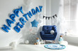© New Africa - Phrase HAPPY BIRTHDAY made of blue balloon letters in decorated room