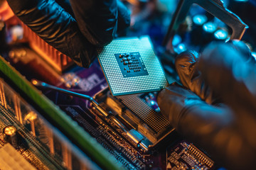 Wall Mural - Engineer repairman holding hands CPU to insert into the socket of the motherboard. Technology hardware in the neon light