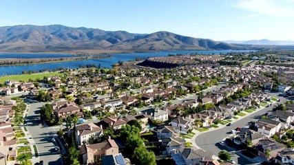 Wall Mural - Aerial view of identical residential subdivision house with big lake and mountain on the background during sunny day in Chula Vista, California, USA.