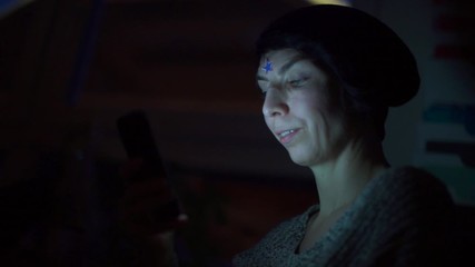 Poster - A girl with a star on her forehead uses a smartphone at night.