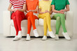 © New Africa - Women wearing bright tights sitting on sofa indoors, closeup