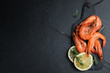 Delicious cooked shrimps with lemon and rosemary on black table, flat lay. Space for text