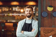 © Studio Romantic - Bearded smiling barman waiter standing on the background of a bar.