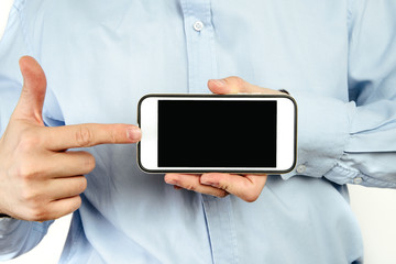 Sticker - Phone in hand on a white background. A man holds a phone with a blank display in his hand. The concept of supplementing content, providing information.