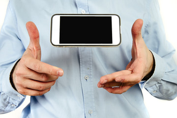 Poster - phone in hand on a white background. a man holds a phone with a blank display in his hand. the conce