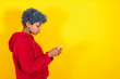 woman with mobile phone isolated on yellow background of afro american ethnicity
