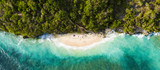 Fototapeta Sypialnia - View from above, stunning aerial view of some tourists sunbathing on a beautiful beach bathed by a turquoise rough sea during sunset, Green Bowl Beach, South Bali, Indonesia.