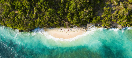view from above, stunning aerial view of some tourists sunbathing on a beautiful beach bathed by a t