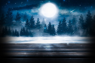 Dark winter background. Wooden table top in the foreground, winter landscape with bokeh in the background