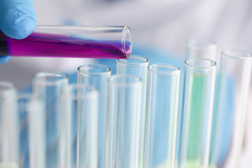 A male chemist holds test tube of glass