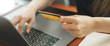 © mojo_cp - Close up hand of woman holding credit card shopping on website.