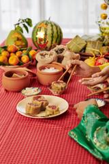 Hands of people eating traditional snacks and dishes at Lunar New Year celebration