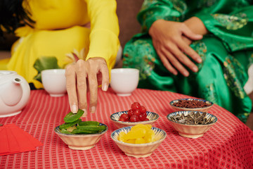 Poster - Small bowls with dried fruits, berries and seeds on small tea table in front of young couple