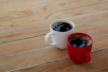 Two red and white mug coffee on wooden