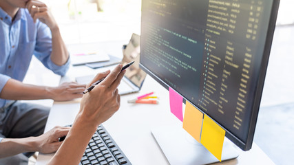 Canvas Print - Pensive programmer working on on desktop pc programming code technologies or website design at office Software Development Company