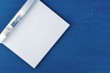 Canvas Print - Top view of open magazine page with copy space on classic blue background