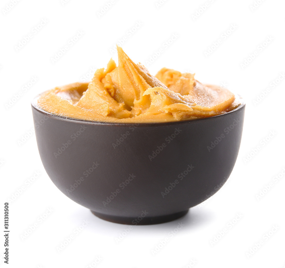 Tasty peanut butter in bowl on white background