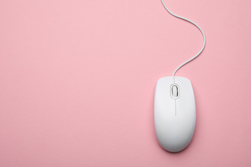 wired computer mouse on pink background, top view. space for text