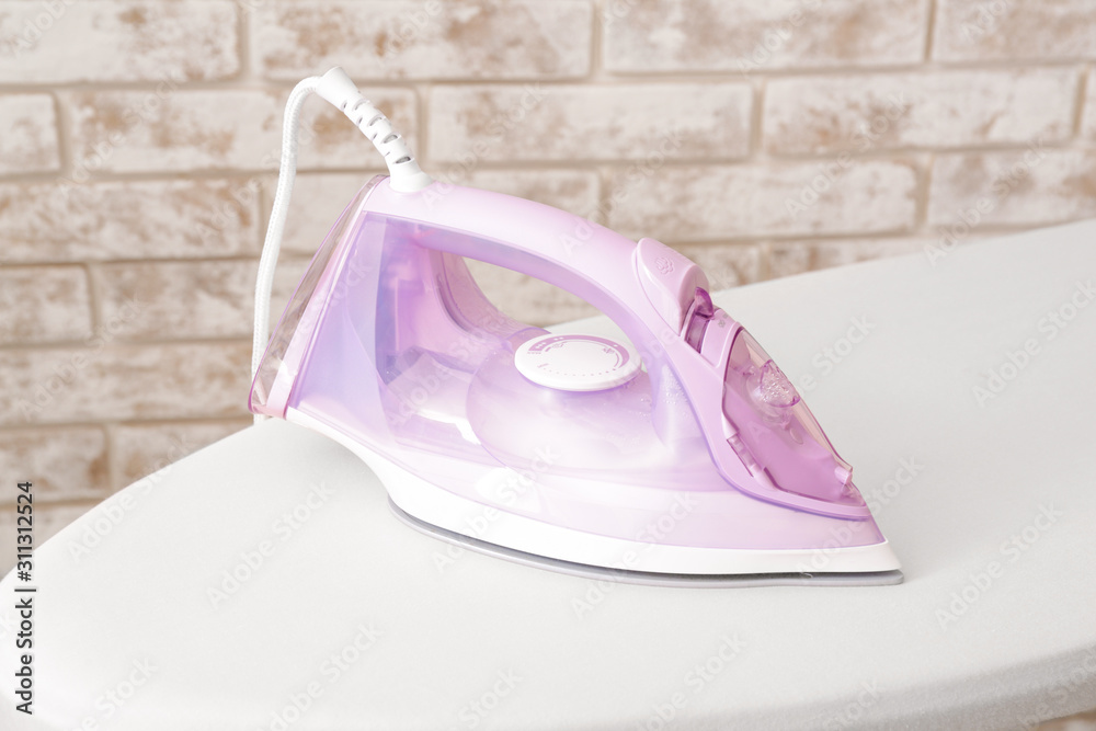 Iron on board against brick background