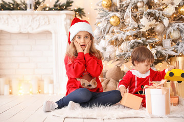 Wall Mural - Little children opening Christmas gifts at home