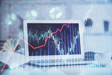 Forex graph hologram on table with computer background. Multi exposure. Concept of financial markets.