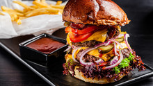 American Cuisine. Large Royal Burger With A Double Meat Cutlet, Bacon, Tomatoes, Cucumbers, Cheese, Skull, Red Onions And A Sauce. Copy Space, Background Image