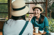 © PR Image Factory - Smiling asian korean female friends drinking matcha tea and laughing. lady in straw hat eating plum snack and laughing listening to sister talking. Japanese architecture style house cafe kyoto japan