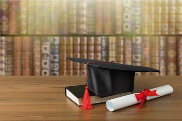 Wall Mural - Graduation hat, book and diploma on wooden table